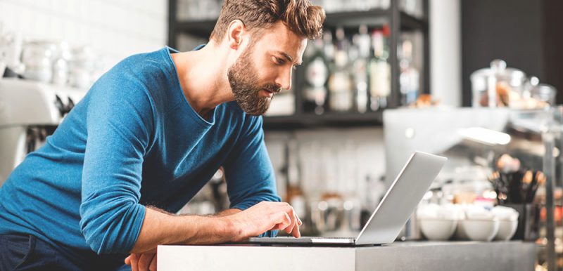 Man working with laptop at the cafe Store owner on laptop