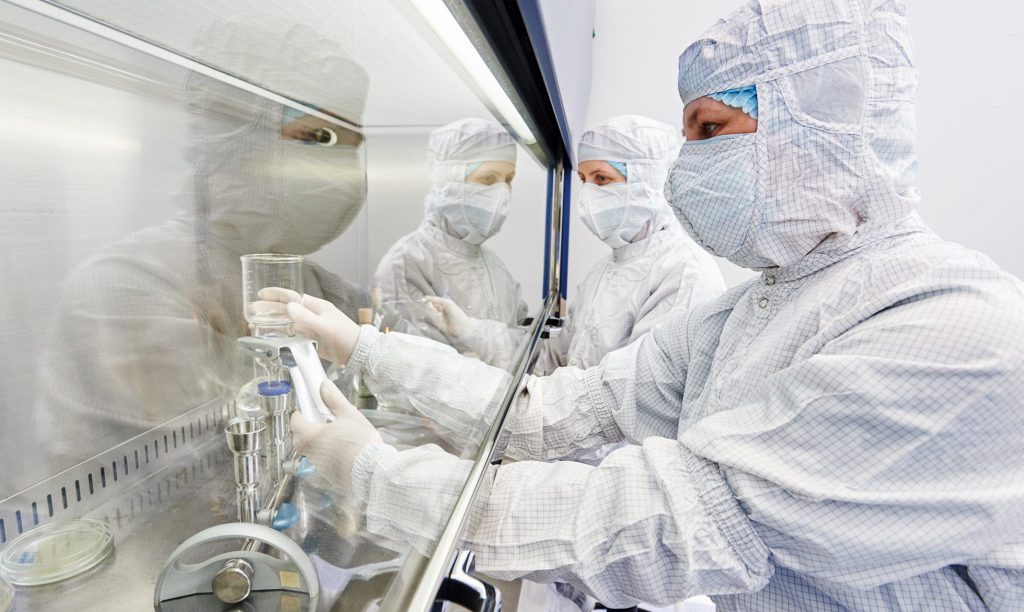 workers in protective uniform at laboratory lab technicians